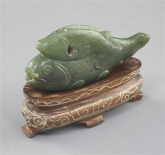 A Chinese spinach green jade double fish snuff bottle, 19th century or earlier, length 6.4cm, later wood stand